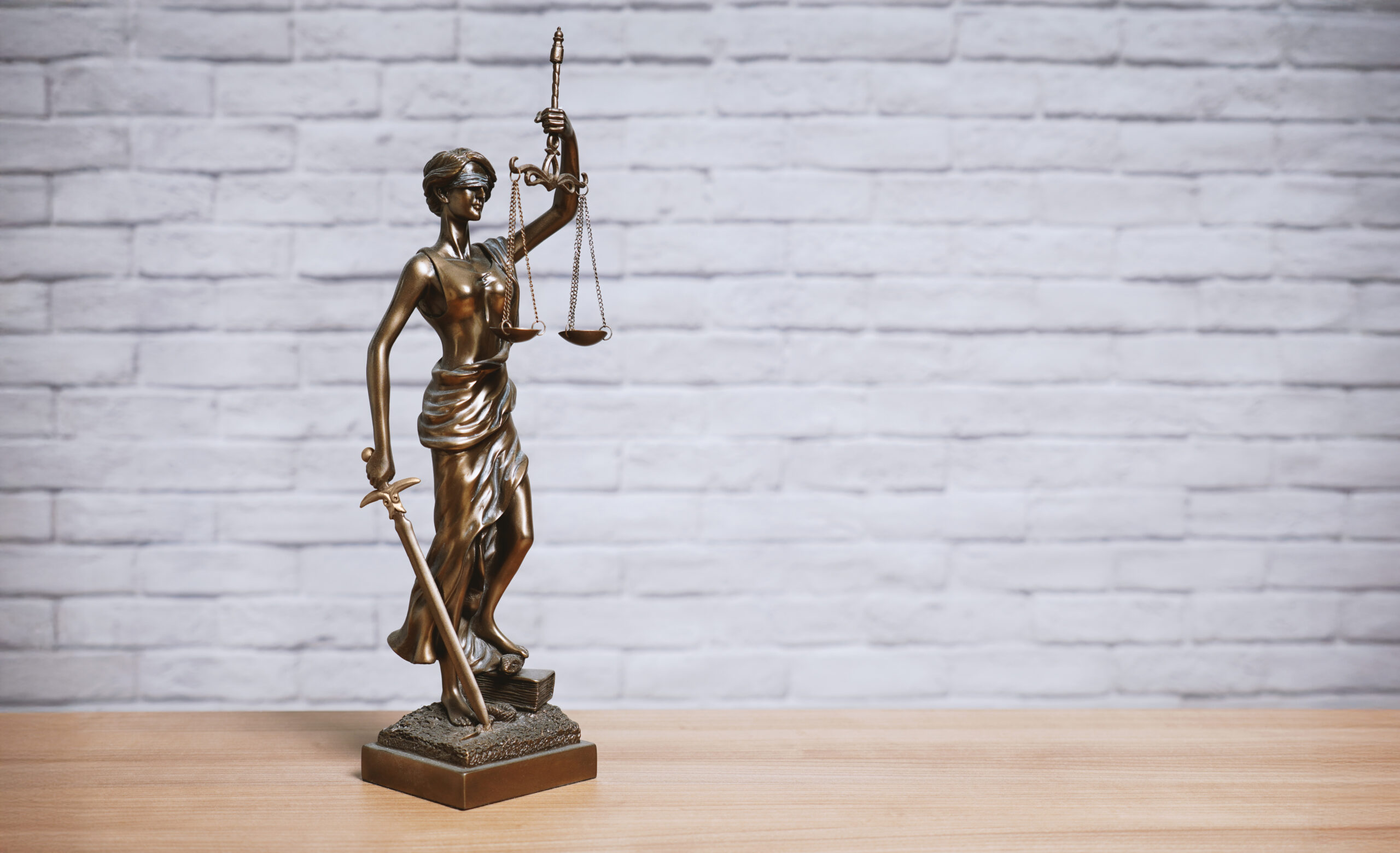 Lady Justice or Justitia the goddess of justice statue on desk - legal law legislation concept